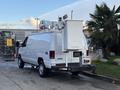 A white 2007 Ford Econoline van equipped with a raised platform and external equipment on the roof for work purposes