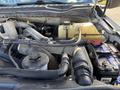 A close-up view of the engine compartment of a 2020 Ford F-550 showing various hoses wires and components including the battery coolant reservoir and intake system