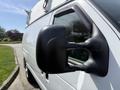 A 2008 Ford Econoline van with a side view mirror prominently displayed in the foreground