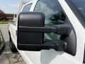 Close-up of the side mirror of a 2011 Ford F-350 SD showing a rugged black design and integrated features for enhanced visibility
