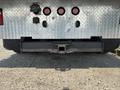 A rear view of a 2020 Peterbilt 330 showcasing its metallic structure with a hitch receiver and several round lights mounted on a diamond plate surface
