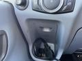 Interior console area of a 2017 Ford Transit showing a storage compartment and a black electrical cord plugged in