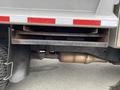 A close-up view of the undercarriage of a 2011 Dodge Ram 5500 showing the exhaust system and support brackets