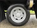 A close-up of a silver wheel of a 2015 Hino 195 truck featuring a six-bolt hub and a black tire with treads