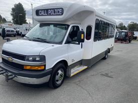 A 2020 Chevrolet Express van modified with a white body and black front grille featuring a sign that says "CALL POLICE" on the roof