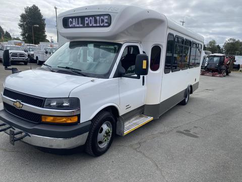 A 2020 Chevrolet Express van modified with a white body and black front grille featuring a sign that says "CALL POLICE" on the roof