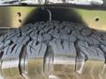 Close-up of a rugged tire tread on a 2013 RAM 2500 showcasing deep grooves and a robust design for enhanced traction and durability