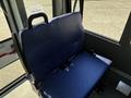 A blue bench seat with seatbelt buckles positioned inside a vehicle