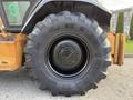 A large black tire from a 2005 Case 570 featuring deep treads and a Michelin brand logo on the rim