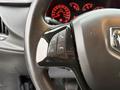 Close-up of a steering wheel from a 2017 RAM ProMaster City with controls for answering calls and adjusting volume