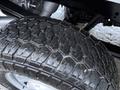 Close-up of a rugged tire from a 2023 Ford F-250 showcasing deep treads and a sturdy build designed for off-road and heavy-duty performance