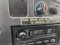 Dashboard of a 2006 Ford Econoline showing a warning label about the park brake and a digital clock displaying 1219
