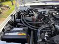 Close-up of the engine compartment of a 1995 Ford F-250 showing the engine components wiring and battery