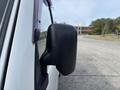 A side mirror of a 2010 Daihatsu Hijet reflecting its black casing with slight wear visible
