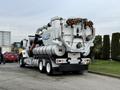 A 2013 International Workstar 7500 truck with a large vacuum tank and multiple warning lights mounted on the rear