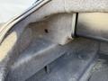 Image of the interior trunk space of a 2004 BMW 6-Series featuring gray carpeting and a smooth surface with a circular hole and a support bracket