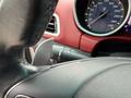 Close-up of the steering wheel of a 2016 Maserati Ghibli featuring paddle shifters and a dashboard with a speedometer and various controls