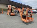 A 2009 JLG E300AJP aerial lift with an orange and white color scheme featuring a telescoping arm and a platform at the front