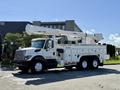 A 2008 International 7500 truck with a white exterior and a hydraulic boom lift mounted on the back for utility work