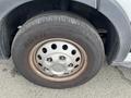 Close-up of a 2023 Ford Transit tire featuring a steel wheel and a treaded tire with the brand name visible
