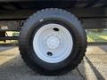 Close-up of a black tire mounted on a white rim featuring intricate bolt patterns typical of a 2015 Hino 358 vehicle