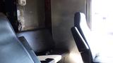 Interior view of a 2004 Freightliner MT45 showing two black seats with a metallic wall in the background