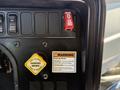A panel featuring a red shut down switch a yellow parking brake button and warning labels indicating how to operate the parking brake