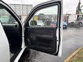 A 2011 Chevrolet Colorado with the driver's door open showing the interior panel and controls