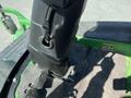 Close-up of the control panel and operator seat of a 2016 John Deere 1585 Terrain Cut featuring levers and foot pedals