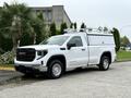 A white 2022 GMC Sierra 1500 with a utility bed and roof racks parked on a street