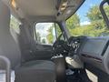 Interior view of a 2022 Freightliner M2 106 showing driver and passenger seats dashboard and steering wheel