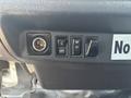 A dashboard panel of a 2012 Hino 338 featuring a circular power outlet and three switches labeled off and for various functions