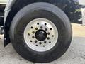 Close-up of a large truck tire mounted on a wheel with several lug nuts visible