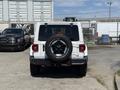 A 2021 Jeep Wrangler viewed from the rear featuring a mounted spare tire on the back and distinct tail lights
