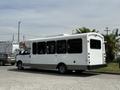 A 2017 Chevrolet Express bus with a white exterior and tinted windows parked in a lot