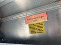 A sign inside a vehicle indicating the truck's clearance height as 10 feet 7 inches with a warning about the potential installation of equipment in the workplace