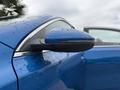A blue 2021 Kia Forte with raindrops on its surface featuring a sleek side mirror design and chrome accents