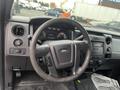 Interior view of a 2013 Ford F-150 showing the steering wheel dashboard and center console with controls and gauges