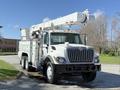 A white 2008 International 7500 truck with a hydraulic boom mounted on top and a flatbed body designed for utility work