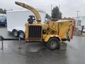 A yellow 2010 Vermeer Corporation BC1000XL wood chipper with a large feeding chute and a hitch for towing