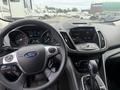 Interior view of a 2014 Ford Escape showcasing the steering wheel dashboard and center console with various controls and displays