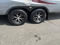 A close-up view of two black wheels with chrome accents mounted on the side of a 2013 Outdoor Wind River trailer