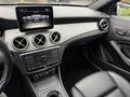 Interior of a 2016 Mercedes-Benz GLA-250 featuring a sleek dashboard with digital display and stylish air vents along with black leather seating