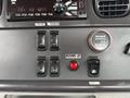 Dashboard controls of a 2021 Freightliner M2 106 featuring various buttons for operational functions an hour meter and a power switch