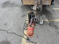 A close-up view of a 2015 Vermeer Corporation BC1200XL wood chipper's hitch with a coiled cable and a red brake lock