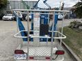 A 2016 Genie TZ-34/20 aerial lift featuring a platform, guardrails, and controls positioned at the rear with visible operational instructions
