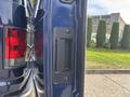 A 2013 Ford E-350 Super Duty door handle positioned on the side door of the vehicle with a black grip and surrounding panel
