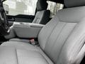 Interior view of a 2014 Ford F-150 showing plush gray fabric seats with a center console and armrest