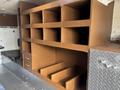 Interior storage compartments of a 2008 International 4400 with several shelves and drawers in a brown finish
