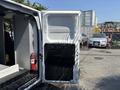 A 2019 Ford Transit 350 with the side door open revealing the interior space and features like a fire extinguisher mounted on the wall